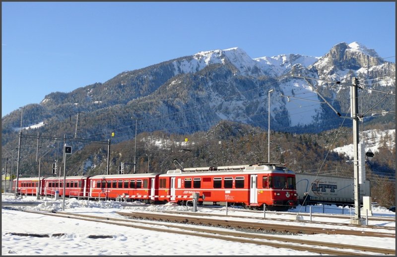 Be 4/4 512 verlsst vor prchtiger Winterkulisse die Haltestelle Ems Werk Richtung Chur. (27.11.2008)