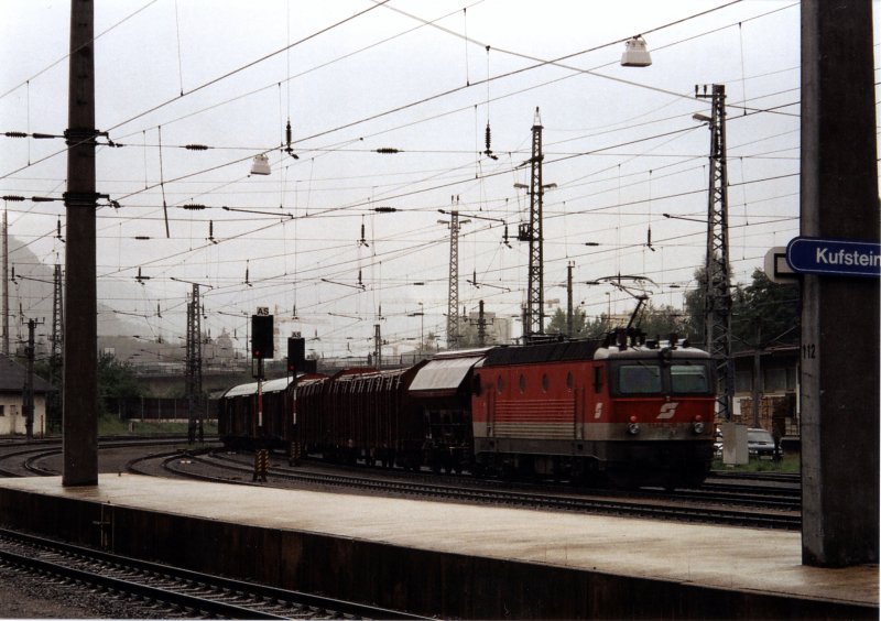 Bei Regenwetter schiebt die 1144 218 einen Schweren Gterzug richtung Brenner nach. Fotografiert im Bahnhof Kufstein im Sommer 2005.