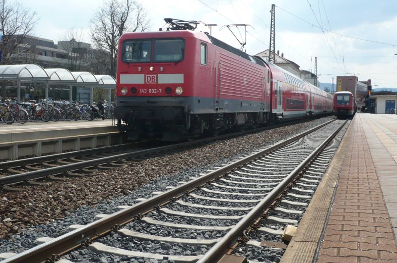 Bei strahlendem Sonnenschein sind soeben die beiden Regionalzge aus und nach Stuttgart Hbf in den Reutlinger Hbf eingefahren.
Der Lokfhrer der 143 802-7 hat bei der Abfahrt ein blaues Wunder erlebt,denn schon ist´s mal wieder passiert - seine Lok streikt. Nun heit es cool bleiben und die Fassung bewahren. Nach ca 10 Minuten, hat dann das Leiden des Lokfhrers und der Lok glcklicherweise doch noch  sein End´ gefunden. Langsam beschleunigend, rollt die 143 mit ihrem Neckar Alb Bahn RE im Schlepptau, aus dem Reutlinger Hbf.
Noch 50 Minuten Fahrtzeit hat er vor sich und ca 10 Minuten Versptung am Hals bis die Landeshauptstadt in Sicht ist.
(7.04.09)