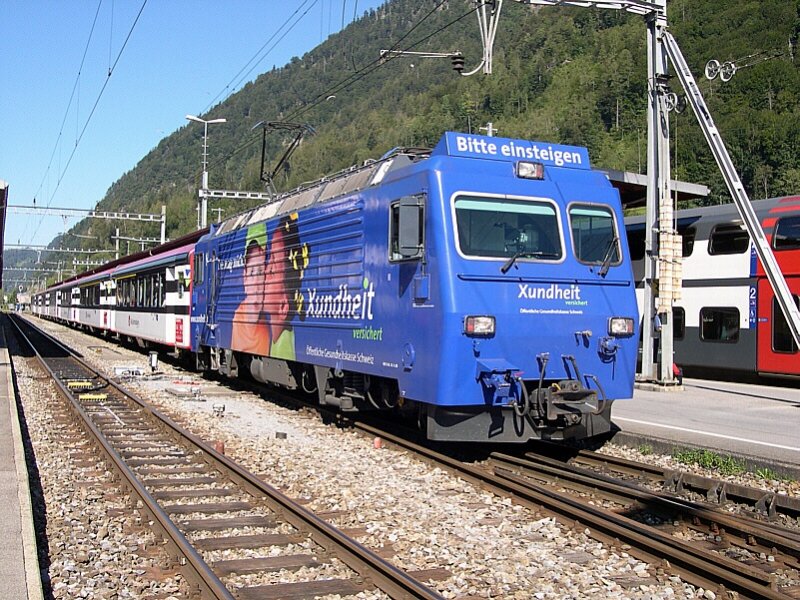 Berner Oberland 2007 - Am schweizer Nationalfeiertag haben wir uns den  Eigertrail  vorgenommen. Im Nachhinein betrachtet eigentlich keine so gute Idee, denn diese Wanderung hatten auch tausend andere Leute geplant. Nichts desto trotz begegnet uns am 01.08.2007 die ZB HGe 4/4 101 962-9 in Interlaken Ost. Sie wird ihr Anhngsel, den IR 2217 Interlaken Ost-Luzern bis nach Meiringen bringen und dort an eine Kollegin bergeben. Die Lok wirbt fr die ffentliche Gesundheitskasse der Schweiz. Die selbe Werbung findet sich auch auf Bussen und Straenbahnen in der Schweiz.
