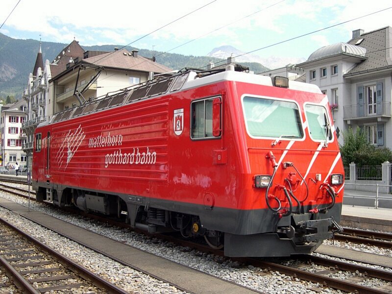 Berner Oberland 2007 - Auch wenn sich mit Erffnung des Ltschberg-Basistunnels fr den Reiseverkehr Ende 2007 der Reiseverkehr der MGB hauptschlich in Visp abspielen wird, so ist trotzdem fr die durchgehenden Glacier-Express Zge in Brig ein Lokwechsel notwendig. So schnell wird sich daran nichts ndern. MGB HGe 4/4 103  Chur  hat am 27.07.2007 den D 907  Glacier Express  von Disentis nach Brig gebracht. Nun hat sie sich eine Pause verdient. Auch wenn mir persnlich die Lackierung der Lokomotiven bei der Brig-Visp-Zermattbahn (BVZ) besser gefallen hat, so tragen doch die Loks auch heute ein sehr ansprechendes Farbkleid.