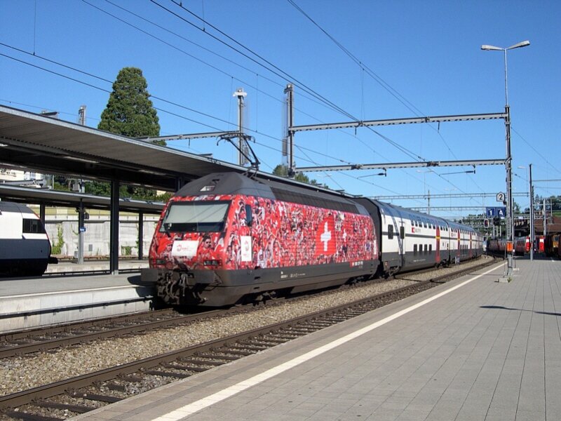 Berner Oberland 2007 - Einen aus IC 2000 Doppelstockwagen gebildeten InterCity schiebt am Morgen die fr die Euro 08 werbende, aber namenlose, SBB Re 460 015-1 aus dem Bahnhof Spiez in Richtung Thun.