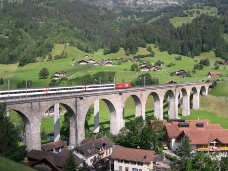 Berner Oberland 2007 - In Richtung Brig ist am 12.07.2007 eine Re 460 der SBB mit IC 828 Romanshorn - Brig auf dem Kanderviadukt bei Frutigen unterwegs. Bei diesem Zug lieen sich die einzelnen Wagenlassen auch nach Farben erkennen. Whrend die 1. Klasse-Wagen schon komplett redesignt wurden, waren die 2. Klasse Wagen noch im klassischen EW 4 Design zu sehen. Nur der Steuerwagen machte eine Aunahme und war bereits redesignt.