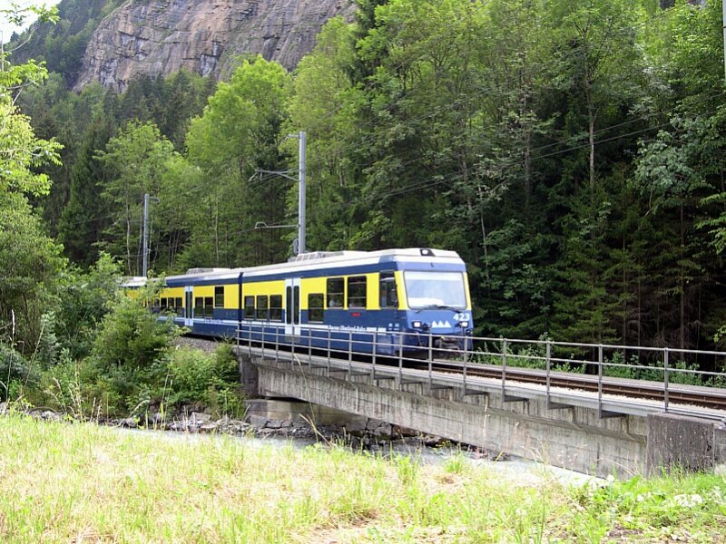 Berner Oberland 2007 - Kurz vor Zweiltschinen begegnet uns am 29.07.2007 wieder die Komposition ABt 423 und ABeh 4/4 307, die sich auf dem Weg nach Interlaken Ost befindet. Wir befinden uns am Bahnbergang Bahnhofstrae aus Richtung Lauterbrunnen kommend. Aus dem besseren Feldweg wird hier eine richtige Strae.