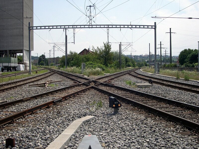 Berner Oberland 2007 - Zwei Bahnen, eine Kreuzung. Diese  doppelte Riesenkreuzungsweiche  findet sich in der stlichen Bahnhofseinfahrt von Kerzers. Von links oben nach rechts unten fhrt die Linie der ehemaligen Bern-Neuenburger Bahn, die von der BLS bernommen wurde. Von rechts oben nach links unten fhrt die SBB-Strecke Lyss - Murten. Diese Kreuzung wird allerdings von planmigen Reisezgen nur von links oben nach rechts unten und von rechts oben nach rechts unten befahren. Namentlich von den RE Bern-Neuenburg und der S5 Bern - Neuenburg / Murten. Die Zge nach Lyss und Bren an der Aare beginnen in Kerzers, hier links hinter uns. Kerzers, 18.07.2007