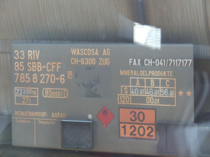 Beschriftung eines Kesselwagens, fotografiert aus einem Silberling heraus, im Konstanzer Bahnhof.