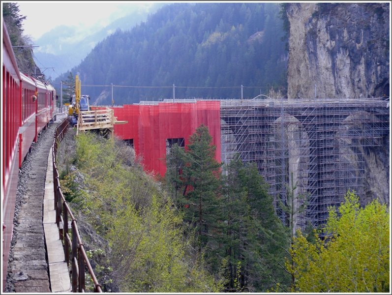 Bis im November wird der Landwasserviadukt saniert und zu diesem Zweck wurde, wie schon gezeigt, dieses Gerst aufgebaut. Als Besonderheit wird die ganze Brcke mit roten Planen verkleidet. Diese Arbeiten sind soeben im Gang. Fotografiert aus dem RE1121 heute morgen auf dem Weg zum Berninapass. (06.05.2009)