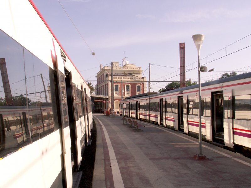 BLANES (Katalonien/Provinz Barcelona), 05.06.2006, Blick vom Bahnsteig auf das Bahnhofsgebäude; links und rechts Vorortzüge