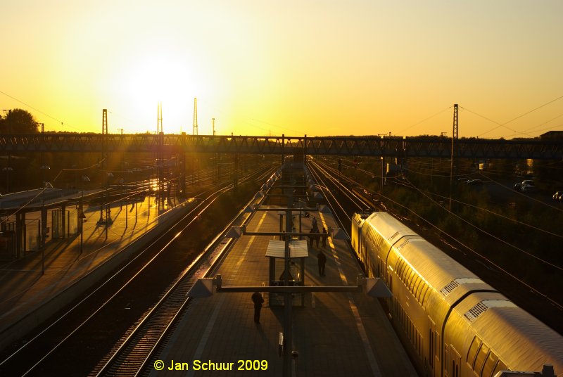 Blaue Bahnhofsbr�cke Buchholz(Nordheide) mit dem westlichen Bahnhofsvorfeld im Gegenlicht der untergehenden Sonne von der Wohlau Br�cke aus fotographiert mit einfahrendem Metronom im Vordergrund.

� Jan Schuur 2009