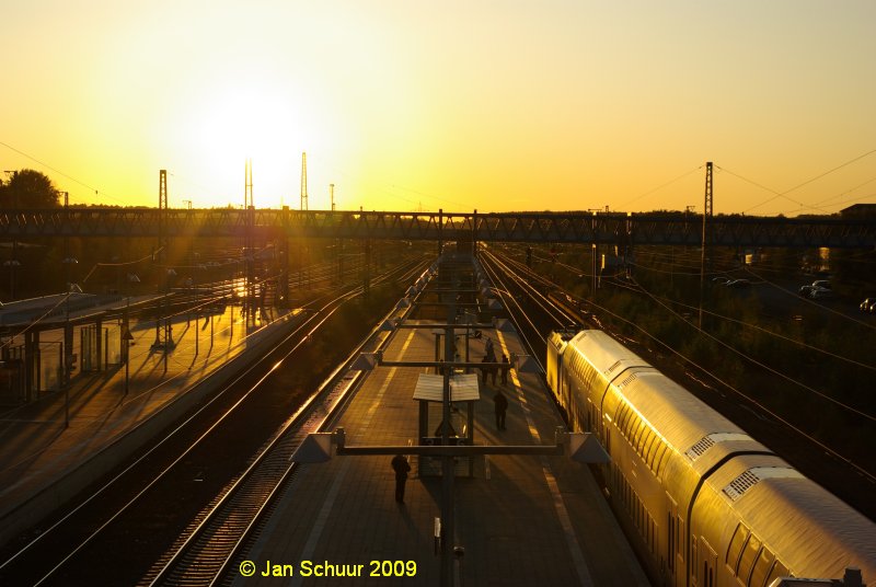 Blaue Bahnhofsbrcke Buchholz(Nordheide) mit dem westlichen Bahnhofsvorfeld im Gegenlicht der untergehenden Sonne von der Wohlau Brcke aus fotographiert mit einfahrendem Metronom im Vordergrund.

 Jan Schuur 2009