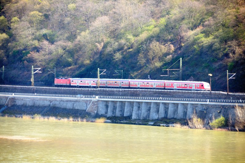 Blick aus den Weinbergen bei Oberwesel (lohnender Aufstieg!!!) auf die rechte Rheinseite Richtung D�rscheid. Eine RB hat gerade den  Kehr -Tunnel unter der  Alten Burg  verlassen und �berf�hrt die sogenannte Rhein-Galerie. (April 2009).