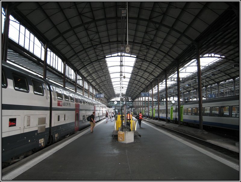 Blick in die Halle des Bahnhof von Luzern an den Gleisen 4 und 5. Auf Gleis 4 wartet der SBB-IR nach Zrich mit seinen Doppelstockwagen. Auf Gleis 6 ist auch noch ein Zug der BLS zu sehen. (18.07.2007)