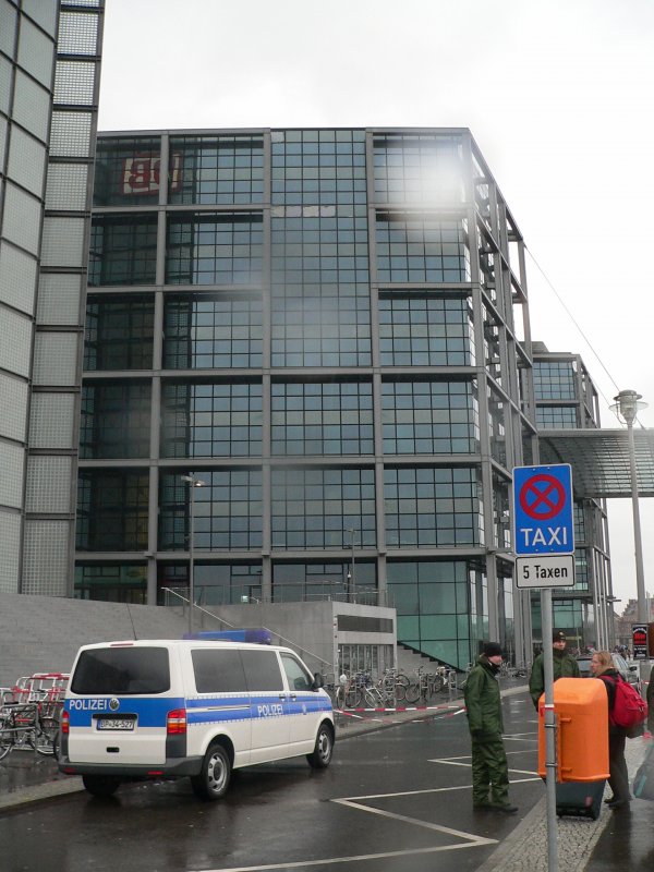 Blick von der Minna-Cauer-Strae (neue Straen im Mitte erhalten nur weibliche Namen, bis ein Verhltnis von 50:50 herrscht) auf die defekte Fassade des Hauptbahnhofs. Am 18.1.2007 war hier in der Nacht bei starkem Sturm ein 2 Tonnen schwerer Trger auf die Treppe gestrzt. Verletzt wurde niemand. Der Fassadenteil ist ein Schmuckelement, nach Zeitungsberichten liegen diese im Gerst, sind aber nicht gesondert befestigt. Die Bundespolizei sperrt seither die gefhrlichen Bereiche ab. Die Minna-Cauer-Strae kann gar nicht, das Friedrich-List-Ufer nur von BVG-Bussen (diese sind wohl weniger gefhrdet) befahren werden. 21.1.2007