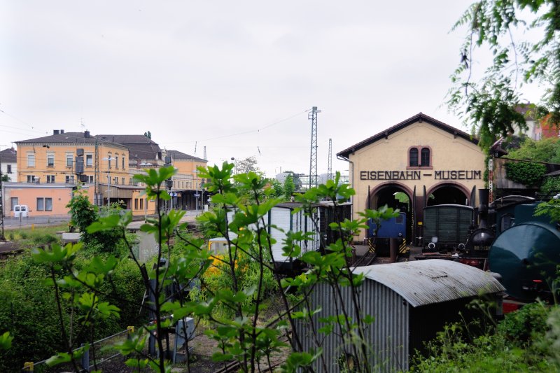Blick vom Zugang des Eisenbahnmuseums Neustadt/Weinstrasse auf das Ausstellungsgelnde und auf Neustadt Hbf. Auf geringem Platz wird versucht, ein Groteil an Exponaten zur Schau zu stellen, teilweise sogar berdacht. (Mai 2009).