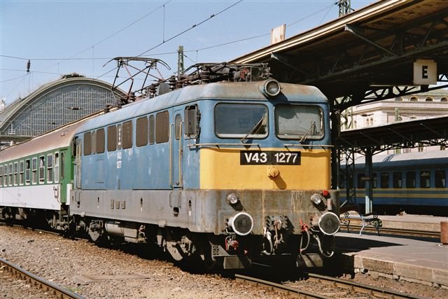 Bo-Bo-Lok V43 1277 vor einem Inter Regio in Budapest-Keleti, August 2004. Die V43 wurde in den 1960er Jahren von einem westeuropischen Firmenkonsortium entwickelt, in Ungarn in grosser Stckzahl weitergebaut und ist heute die Standardmaschine der Ungarischen Staatsbahn MAV.