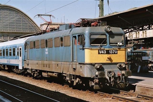 Bo-Bo-Lok V43 1370 vor einem Inter City in Budapest-Keleti, August 2004. Die V43 wurde in den 1960er Jahren von einem westeuropischen Firmenkonsortium entwickelt, in Ungarn in grosser Stckzahl weitergebaut und ist heute die Standardmaschine der Ungarischen Staatsbahn MAV.
