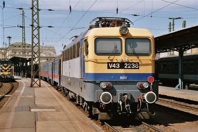 Bo-Bo-Lok V43 2238 vor einem Wendezug in Budapest-Keleti, August 2004. Die V43 wurde in den 1960er Jahren von einem westeuropischen Firmenkonsortium entwickelt, in Ungarn in grosser Stckzahl weitergebaut und ist heute die Standardmaschine der Ungarischen Staatsbahn MAV.
