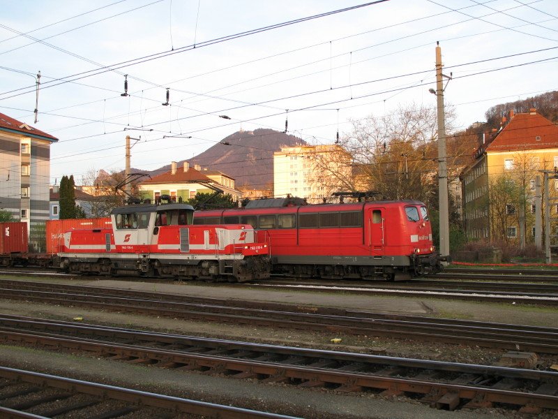 Br 151 060-1 steht mit ihrem Containerzug im Salzburger HBF und wartet auf die Ausfahrt richtung Freilassing. Im Vordegrund steht 1163 013-4, und wartet auf neue Arbeit. 