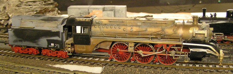 BR 18 314: Hier ein Foto aus der Umbauphase.
Ein paar Infos:
Die Lok hab ich mal bei EBAY geschossen. Kleinserienmessingmodell aus den 60ern. Ich stellte die Lok vor mich hin und dachte: ach du Schreck, an der stimmt nicht viel.
War auch so. Fhrerhaus irgendwas in der Mitte zwischen Lnderbahn und Neubau. Am Tender war alles verkehrt. Die WLB vllig daneben.
Leider ist die Schrze auch ein Kompromiss. In den 60ern musste wegen der Radien das Drehgestell unten durch. Eigentlich ist die noch bauchiger.
Also berlegte ich, was ich nun tun sollte. Das Modell war Vollmessing. Das war fr mich ne Nummer zu gross. Ich entschloss mich, zu freveln. Alles, was falsch war, abgeltet. Fhrerhaus und Tendergehuse sind von PIKO, also Plaste, beides hab ich aber umbauen mssen, so kam dann wenigstens noch Blech zum tragen. Die Steuerung habe ich ergnzt und dem Motor ne Schwungmasse verpasst. Ein paar Weinert-Teile sind auch dran. Das Tenderfahrgestell bekam die richtigen Abmessungen (krzer), Dazu musste der Boden in der Mitte durchgesgt werden. Auch da Ergnzung durch Weinert-Teile. Da ich ja auf Messing arbeitete, konnte ich endlich mal lten.


