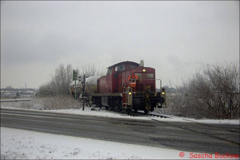 BR 295 092-1 berquert im Winter 2003 auf dem Weg zum Bayerwerksgelnde mit einem Kesselwagen einen Bahnhbergang in Brunsbttel. 