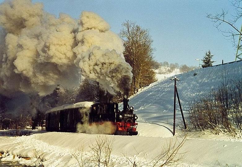 BR 99 1542 nach der Ausfahrt aus dem Bahnhof Steinbach. Die langsam untergehende Sonne verleiht der Dampffahne eine interessante Farbgebung.