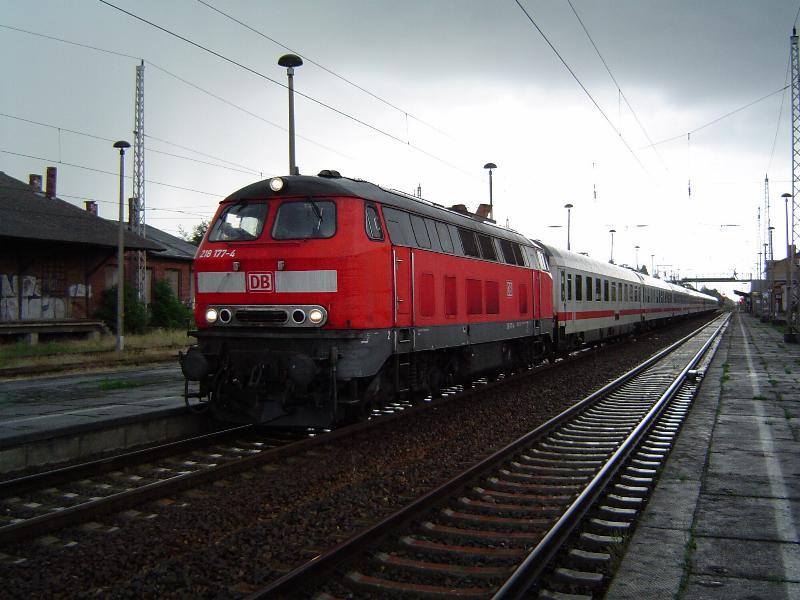 BR218 177-4 befindet sich hier mit ihrem IC2637  Urlaubsexpress Mecklenburg-Vorpommern  bei mieserablem Regenwetter im Greifswalder Hbf. Dieser IC verkehrt von Hamburg-Altona aus ber Stralsund und Greifswald auf die Insel Usedom bis hin zum Seebad Heringsdorf, allerdings nur saisonal von Mai bis Oktober und bringt so die Urlauber whrend des Sommers jedes Wochenende an die Ostsee. Doch an diesem Tag hat es kaum einen Urlauber in diesen Zug verschlagen! Aufgrund der Tatsache, dass die Strecke ab Zssow auf der gesamten Insel Usedom nicht elektrifiziert ist, ist somit eine solche Diesellok vor dem IC vonnten. Abgelichtet am 20.08.04