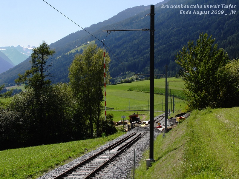 Brckenbaustelle taleinwrts von Telfes, eine von vielen Baustellen diesen Sommer auf der Stubaier Strecke talein von Nockhofweg, es wurden etliche hundert Meter Strecke erneuert, beide Weichen in Telfer Wiesen, das Fundament am talseitigen Ende der Mutterer Brcke, der Bogen wurde vllig neu betoniert und eben diese kleine Brcke wenige hundert Meter talein des Telfer Bahnhofs, die auch vllig neu betoniert wurde. Diese Brcke ist eines der ltesten Photomotive an der Stubaier Strecke, schon im altbewhrten Buch  Die Sillwerke zu Innsbruck  ist sie in der Beschreibung des elektrischen Teils zu sehen. Mich hat auch die Erdungsstange fasziniert - in Telfes, in unserem Rcken, steht das nchste Unterwerk. Ende August 2009 kHds