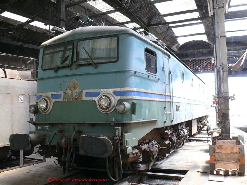 CC 7002 in der Rotonde (Rundlokschuppen).

Die Reihe CC 7000 war die erste Hochleistungs-Drehgestellellok der SNCF und die erste wirkliche Neuentwicklung nach dem Krieg.
Sie wurde 1949 in 2 Exemplaren gebaut und nur die CC 7002 ist erhalten und steht heute in Ambrieu.
Die CC 7000 war die Vorlage fr die erfolgreiche Reihe 7100, die sich nur unwesentlich unterscheidet.

08.06.2007   Ambrieu Dpot
