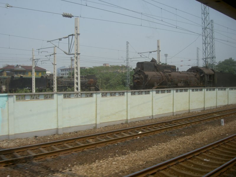 CN Dampflokomotiven abgestellt am 05.08.2006 in Hangzhou. Diese stehen hinter einer Lrmschutzmauer? oder eher einem Schutz gegen unbefugtes Betreten der Bahngleise. Diese Exemplare sehen nicht danach aus, als ob sie noch einsatzfhig wren.