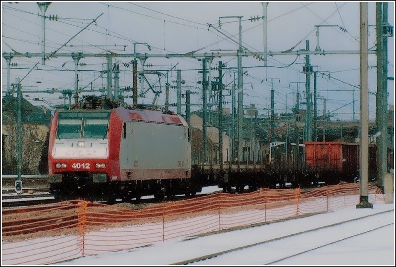 Da wir keine digitalen Bilder von 2005 mehr haben (Computerabsturz), haben wir das Scannen eines Papierabzugs gewagt. E-Lok 4012 durchfhrt am 27.02.05 im leichten Schneegestber den Bahnhof von Bettemburg mit einem Gterzug am Haken. (Hans)