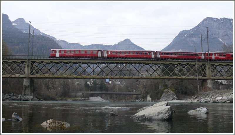 Da wo sich Hinter- und Vorderrhein zum Rhein vereinigenn berspannt diese Brcke das Tal. Gleich nach der Brcke teilen sich die beiden RhB Linien nach St.Moritz und Disentis. Dieser Be 4/4 Vorortpendel hat soeben Reichenau-Tamins verlassen. (02.04.2009)