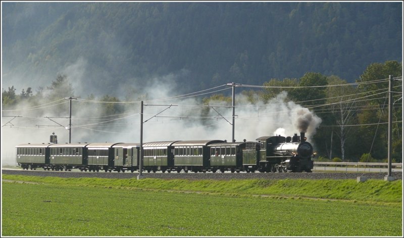 Dampfextrazug 9259 von Sumvitg-Cumpadials nach Landquart. Die G 4/5 107 zieht einen gutbesetzten Zug aus historischen RhB-Wagen ber die Ebene bei Felsberg und deckt die parallele Autobahn mit ihrem wrzigen Rauchschleier ein. (05.10.2008)