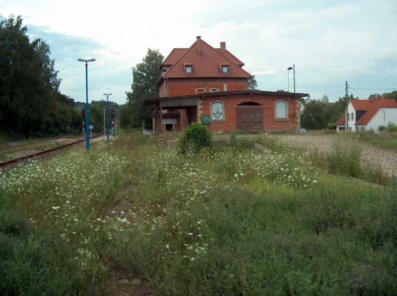 Das Bahnhofsgebude mit der ehemaligen Gterverladerampe und zugewachsenen Rangiergleisen, am 26.07.2007 in Freyburg.