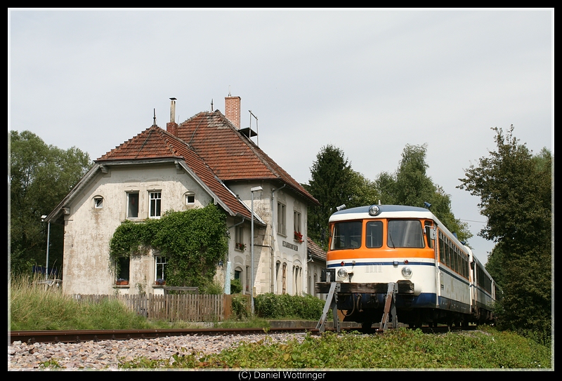 Das Bahnhofsgebude von Neckarbischofsheim Nord. Rechts abgestellt stehen 3 NE81 mit einem MAN VT davor.