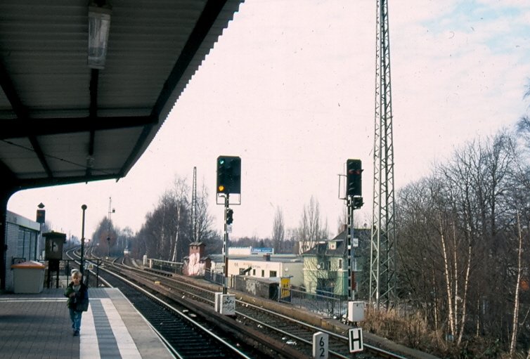 Das Einzige, mir bekannte Signal, welches mit 2 verschiedenen Eisenbahn - Signalsystemen gearbeitet hat. In Hamburg - Eidelstedt stand dieses kuriose Einzelstck weil hier die Hamburger S-Bahn mit Sv-Signalen (Signalverbindungen) und die AKN mit Hp-Signalbgriffen fhrt. Hier: Hp2 (Langsamfahrt) als Ausfahrsignal fr die AKN. Rechts daneben kann man brigens ein  normales  Lichtsignal sehen. Der Unterscheid in der Breite ist schon markant. Inzwischen stehen hier jedoch KS-Signale. Hinweis: eigescanntes Dia