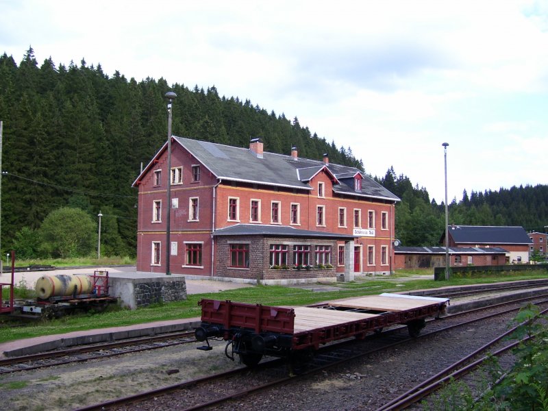 Das Empfangsgebude des Bahnhofs Schnheide Sd. Im Vordergrund ein in der Aufarbeitung befindlicher Flachwagen des FHWE. (26.07.09)