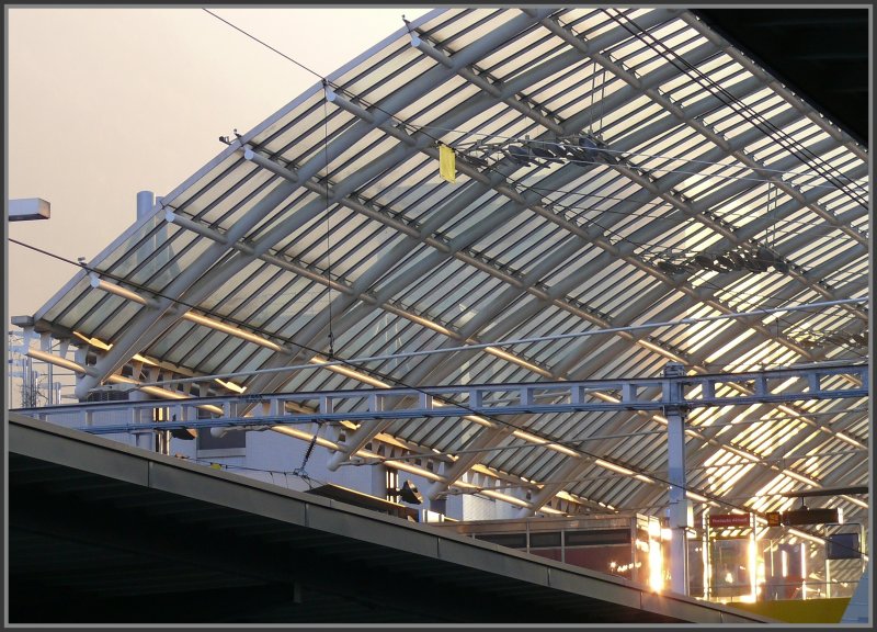 Das Glasdach der Postautstation ber den >Geleisen des Bahnhofs Chur wlbt sich in den Abendhimmel. (28.10.2007)