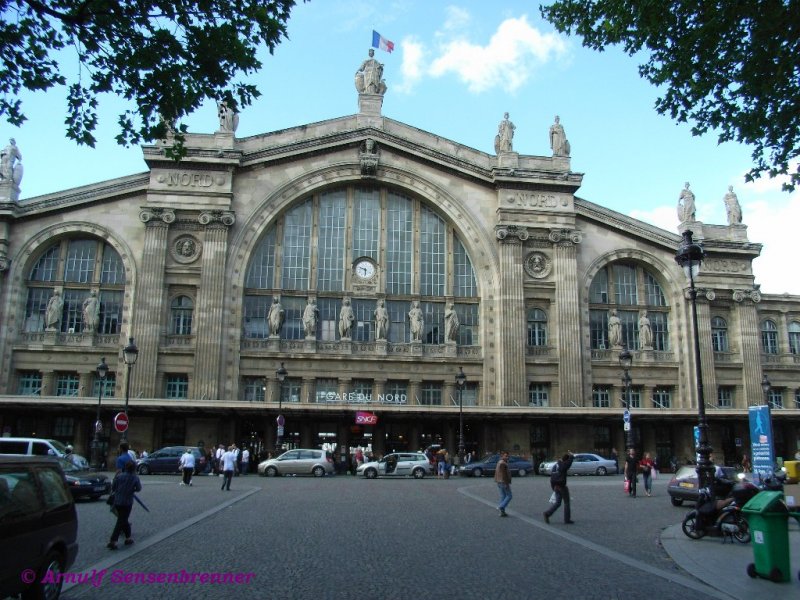 Das imposante Hauptportal des Gare du Nord in Paris.
Der erste Bahnhof an dieser Stelle wurde 1846 eingeweiht. Da dieser sehr schnell den Verkehrsansprchen nicht mehr gewachsen war, wurde von 1861-1865 an seiner Stelle ein Neubau errichtet. Die Fassade ist 180 m lang und hat eine Hhe von 43 m.
Bedingt durch den weiter rapide zunehmenden Verkehr (insbesondere den Vorortverkehr) wurde dieser Bahnhof 1875, 1889, 1900 sowie in den 1930er und 1960er Jahren und auch fr den TGV-Verkehr nach Norden und Grobritannien laufend erweitert und ausgebaut.
Mit 180 Millionen Reisenden (inklusive Nahverkehr) pro Jahr gilt der Gare du Nord als der am meisten frequentierte Personenbahnhof Europas. Weltweit wird dies nur in den beiden Tokioter Bahnhfen Shinjuku und Ikebukuro bertroffen.
23.06.2007
