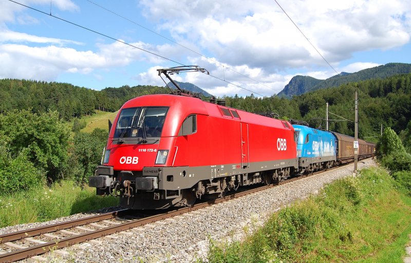 Das Ochsendoppel 1116 172 und
1016 023 ist am 08.07.2009 mit
dem Papierzug 48930 zwischen
Klaus und Micheldorf in der
Ortschaft Schn unterwegs
gewesen.