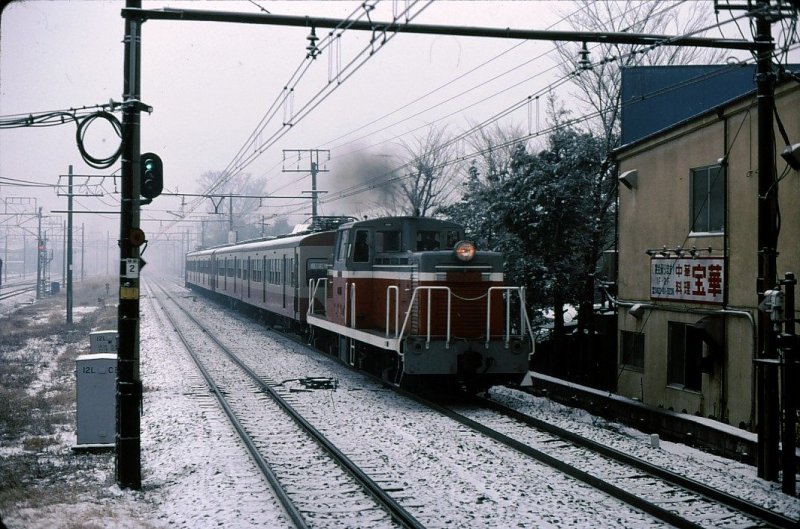 DD13: Im Bild zieht die DD13 81 einen Zug des Seibu-Konzerns, der hier nicht von sich aus fahren darf, von einer Seibu-Inselbetriebsstrecke auf das Stammnetz zurück. Tokyo-Higashi Koganei, 13.Januar 1980.