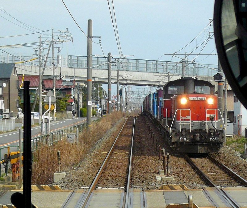 DD51: Hier kommt ein Containerzug mit der DD51 857 im neuen Anstrich der JR Freight (grau-rot-schwarz) bei Asahi an der Bucht von Ise entgegen. 26.Februar 2009. (Aufnahme durch das Fenster in der Führerstand-Rückwand eines Nahverkehrszugs.)