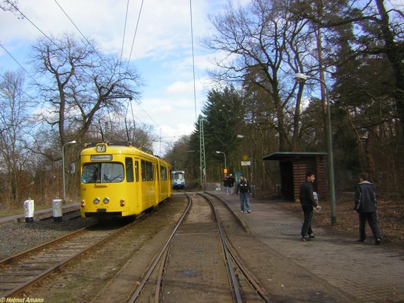 Der 9. Zug der Linie 12 nach Schwanheim hatte am 25.03.2006 die Haltestelle Waldfriedhof Goldstein kurz vor dem Eintreffen des Museumstriebwagens 111 der Bauart O (ex902) verlassen, der an diesem Tag auf Sonderfahrt unterwegs war. Der 8. Zug der Linie 12 mit dem Pt-Triebwagen 690 befindet sich im Hintergrund auf dem Weg nach Fechenheim.