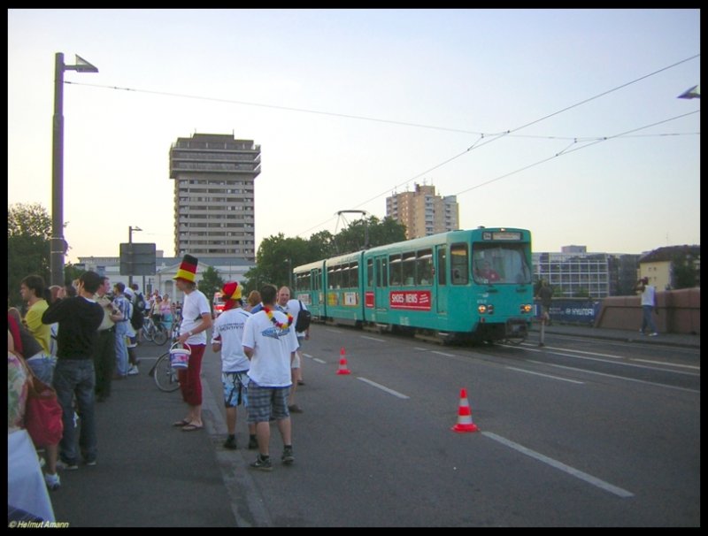 Der 9. Zug der Linie 14 nach Neu-Isenburg fuhr mit Pt-Triebwagen 676 am 04.07.2006 ber die Ignatz-Bubis-Brcke, whrend die Fuballfans gebannt auf der im Main verankerten Grobildleinwand der Main-Arena das Halbfinalspiel Italien gegen Deutschland verfolgten. 