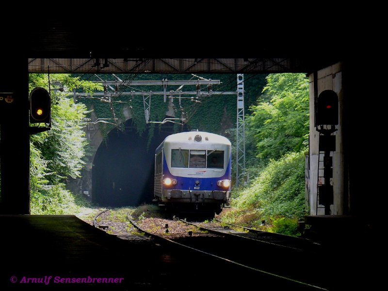 Der aus dem Tunnel kam: Der blau-silber lackierte EAD-Dieseltriebzug XR8647+X4635 kmpft sich hier hoch.
Direkt vor dem Halt Lyon Gorges-de-Loup endet der Tunnel, der vom Bahnhof Lyon Saint-Paul steil hier hoch fhrenden Strecke.
Die Anstrengung der betagten Zge hier hoch kann man sehr gut hren (und auch riechen). In Zukunft sollen hier mal Tram-Train (Stadtbahnen) verkehren
Die berbauung im Vordergrund ist die hier hochgelegene Metro, zu der hier umgestiegen werden kann.
09.06.2007  Lyon Gorges-de-Loup
