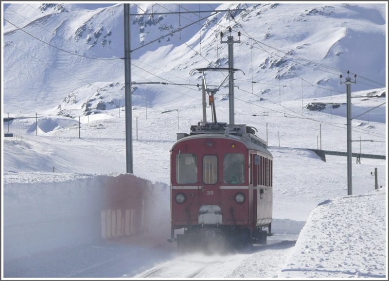 Der Dienstzug mit ABe 4/4 I 35 saust an mir vorbei Richtung Alp Bondo. Im Hintergrund erkennt man die obere Berninabachbrcke und die 70 Promille Rampe hinauf zum Pass. (10.03.2009)