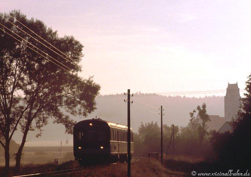 Der Esslinger Triebwagen der BBG Stauden verlsst im Sonnenaufgang des 10. Juni 2003 die Ortschaft Billenhausen.