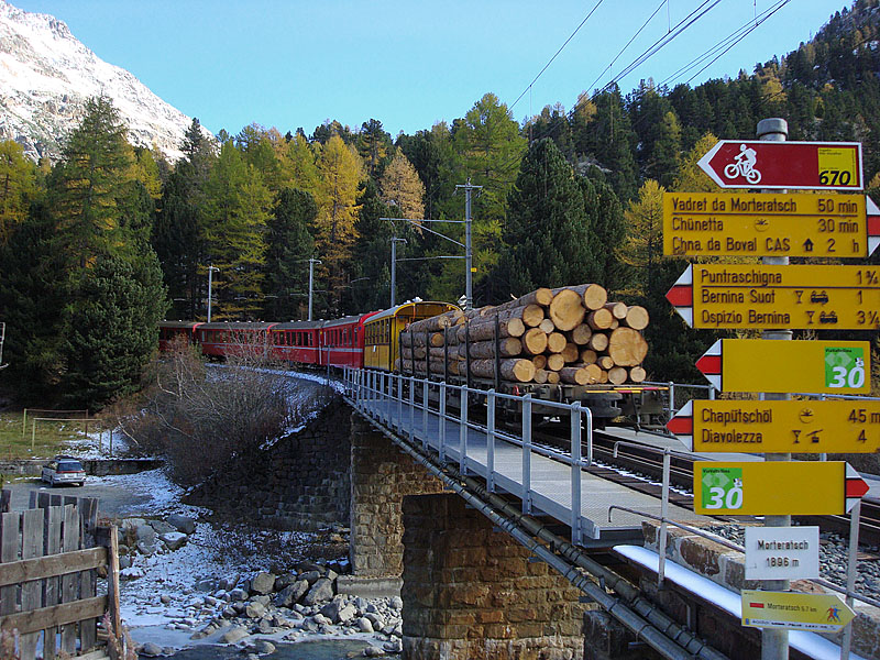 Der gemischte Personen- und Gterzug kurz nach Abfahrt in die steile Rampe. Rechts im Bild der Schilderwald mit Wanderwegen und Bikerouten. Haltestelle Morteratsch, 16. Okt. 2009, 13:16
