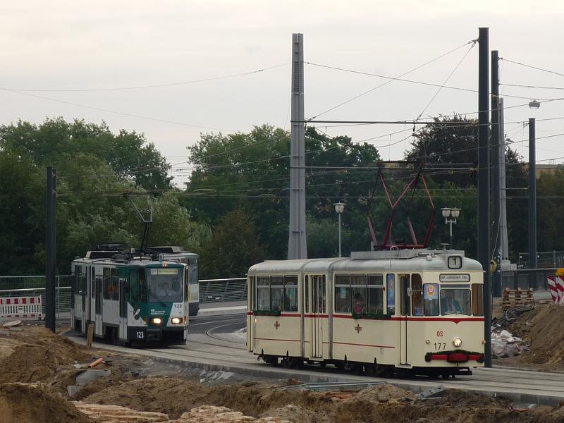 Der historische Triebwagen 177 (Gotha-Gelenkwagen) wird von Tatra-Doppel 123/124 verfolgt. Hier schlngeln sich beide die neue Streckenfhrung am Alten Markt entlang. Am Zielschild des Traditionswagens steht 'Prof.-Ludschuweit-Allee', der alte Name der heutigen Kastanienallee. Potsdam, 2009-10-03.