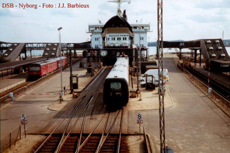 Der IC3 5003 ist gerade aus Odense angekommen und fhrt auf dem
Kronprins Frederik. Links ist ein Tw als Regionalzug aus Odense schon frher angekommen : seine Passagieren mssen zu Fuss auf dem Schiff einsteigen.  Alles was Sie da sehen ist seit lang total verschwunden.  Nyborg - August 1995 - Foto : J.J. Barbieux