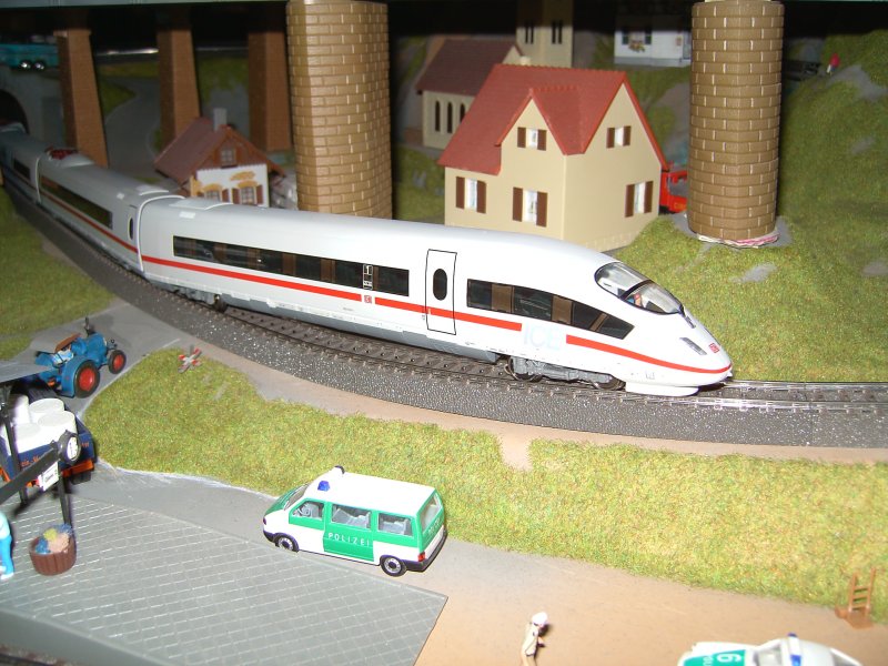 Der ICE 3 kempft sich dehn Berg hoch. Am Bahnbergang steht ein alter Lanz Buldog, welch ein kontrast.